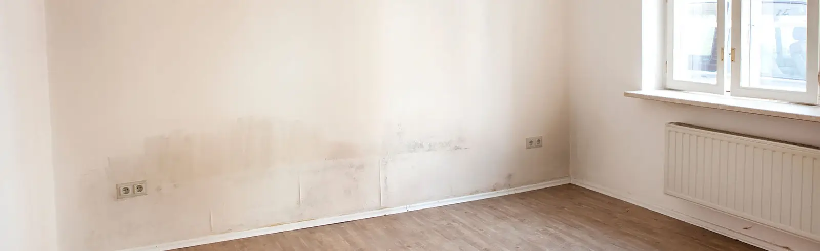 Ansicht einer feuchten und bereits von Schimmelbefallenen Wand in einer Wohnung